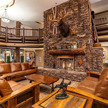 The Grand Hotel At The Grand Canyon Тусан Екстериор снимка The photo shows a cozy lodge-style interior with a warm, inviting atmosphere. The focal point is a large stone fireplace with a mounted deer head above it. Surrounding the fireplace are comfortable leather sofas and wooden furniture, creating a rusti
