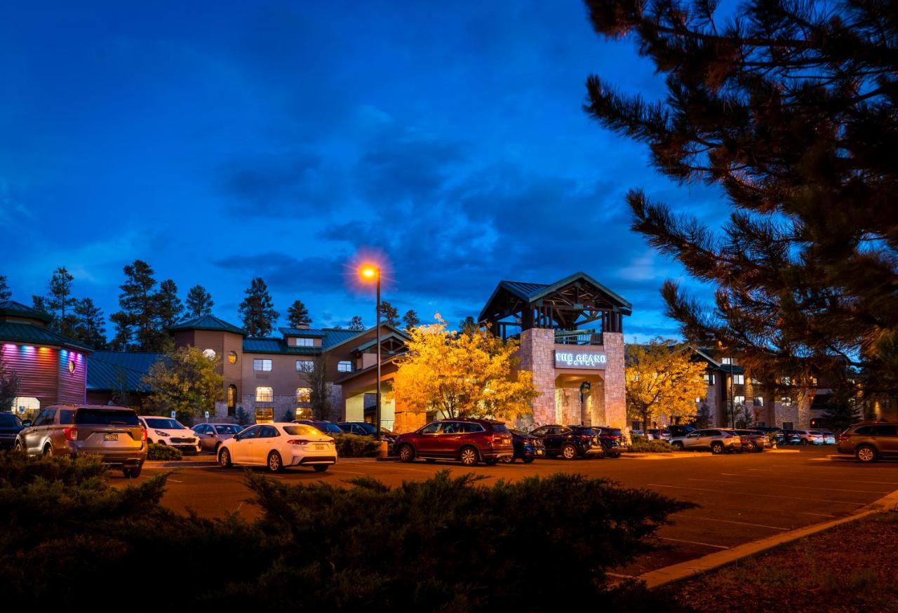 The Grand Hotel At The Grand Canyon Тусан Екстериор снимка The photo shows a hotel or lodge building during twilight, with a blue sky and clouds. There are several cars parked in front, and some illuminated trees add warmth to the scene. The architecture features a combination of stone and wood elements, and