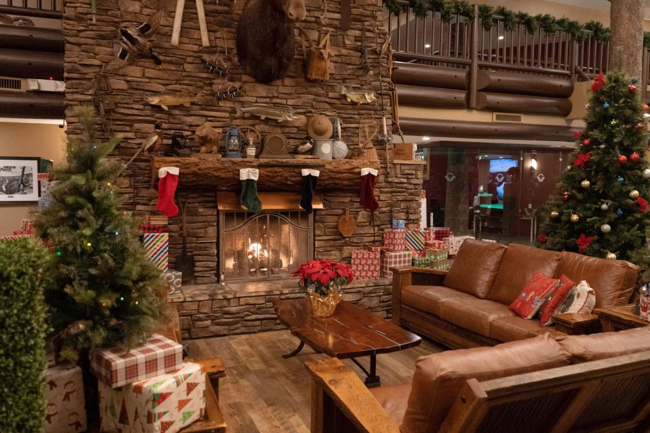The Grand Hotel At The Grand Canyon Тусан Екстериор снимка The photo depicts a cozy interior setting, likely a lodge or cabin, decorated for the holiday season. In the center, there is a stone fireplace with a roaring fire, adorned with festive stockings hanging from the mantel. Above the fireplace, there ar