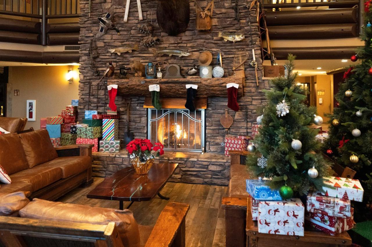 The Grand Hotel At The Grand Canyon Тусан Екстериор снимка The photo depicts a cozy lodge-like interior, highlighted by a large stone fireplace at the center. Above the fireplace, there are various decorative items, including fishing gear and a mounted animal head. The fireplace is adorned with colorful Chri