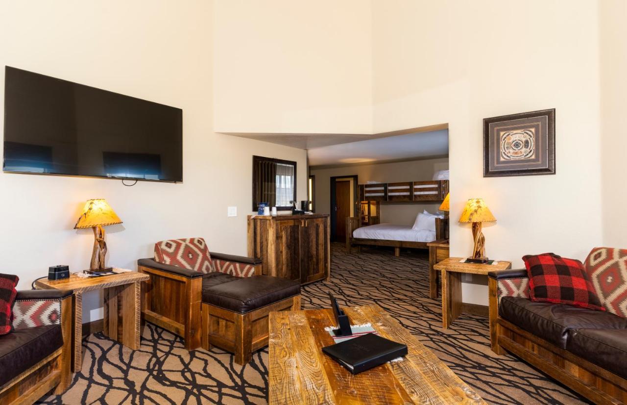 The Grand Hotel At The Grand Canyon Тусан Екстериор снимка The photo shows a cozy living area of a hotel or lodge. It features rustic wooden furniture, including armchairs and a coffee table. A large flat-screen TV is mounted on the wall. There are lamps with warm lighting and decorative patterns on the furn