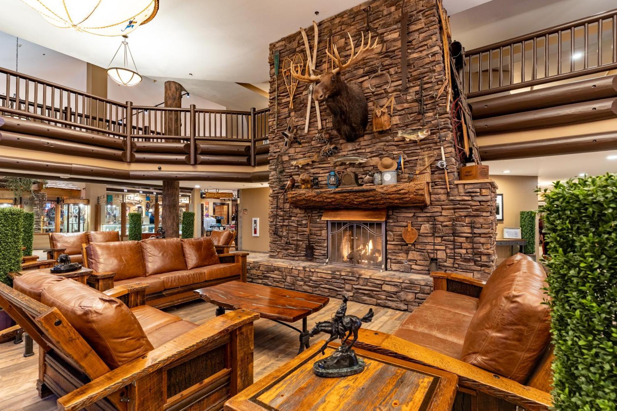 The Grand Hotel At The Grand Canyon Тусан Екстериор снимка The photo shows a cozy lodge-style interior with a warm, inviting atmosphere. The focal point is a large stone fireplace with a mounted deer head above it. Surrounding the fireplace are comfortable leather sofas and wooden furniture, creating a rusti