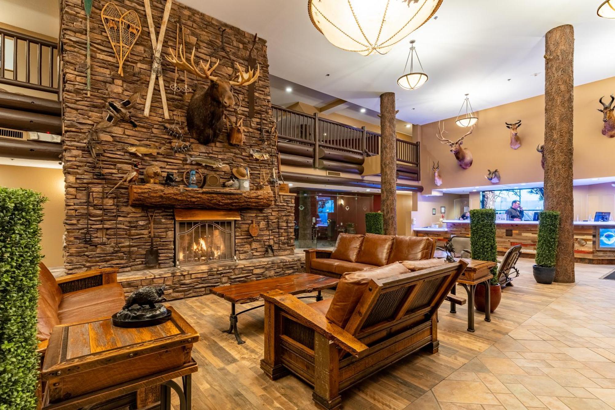 The Grand Hotel At The Grand Canyon Тусан Екстериор снимка The photo shows a cozy lobby area with a rustic design. A large stone fireplace is the focal point, adorned with a mounted animal head and various decorative items like snowshoes and antlers. The seating consists of wooden furniture, including a coup